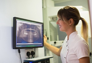 Dental employee examining an X-ray of a patient’s mouth